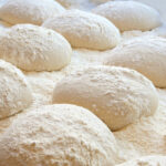 This photo shows balls of dough on a tray.