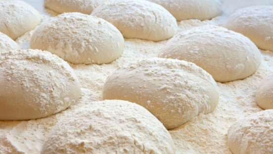 This photo shows balls of dough on a tray.