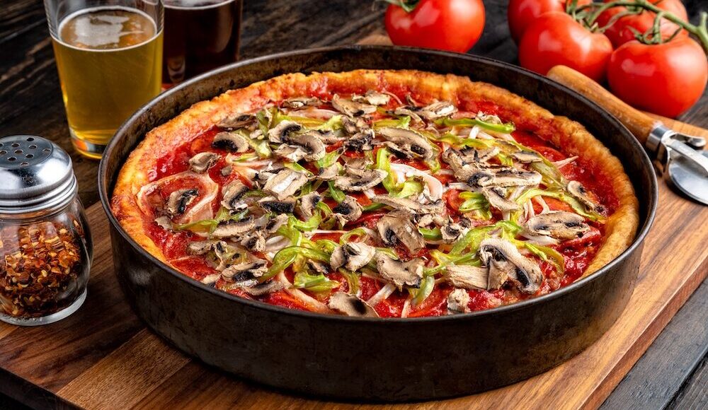 This photo shows a deep-dish pizza from Pizzeria Uno, topped with mushrooms and green bell pepper strips.