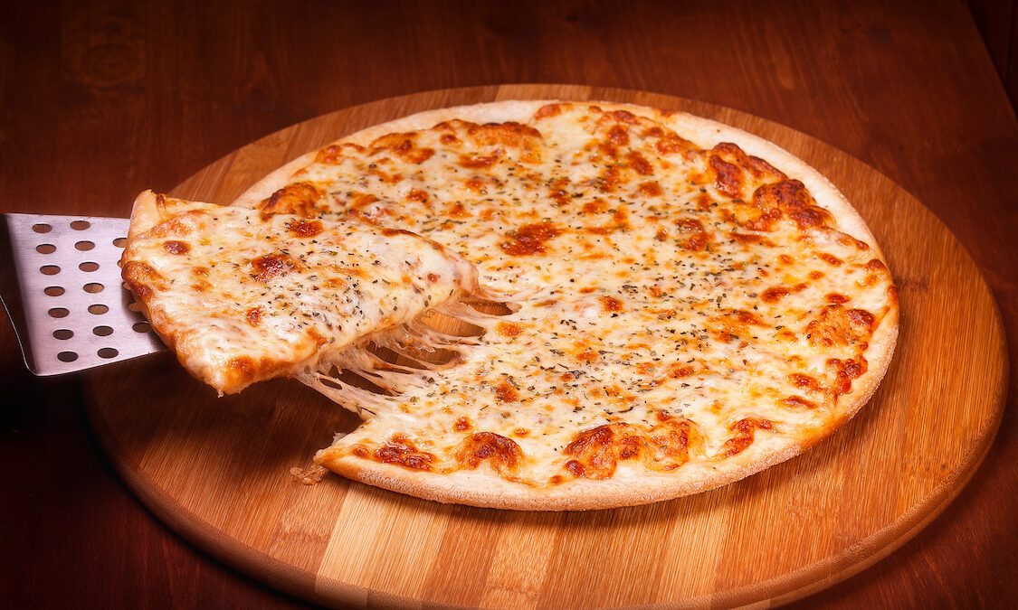 This photo shows a slice being removed from a thin-crust cheese pizza.