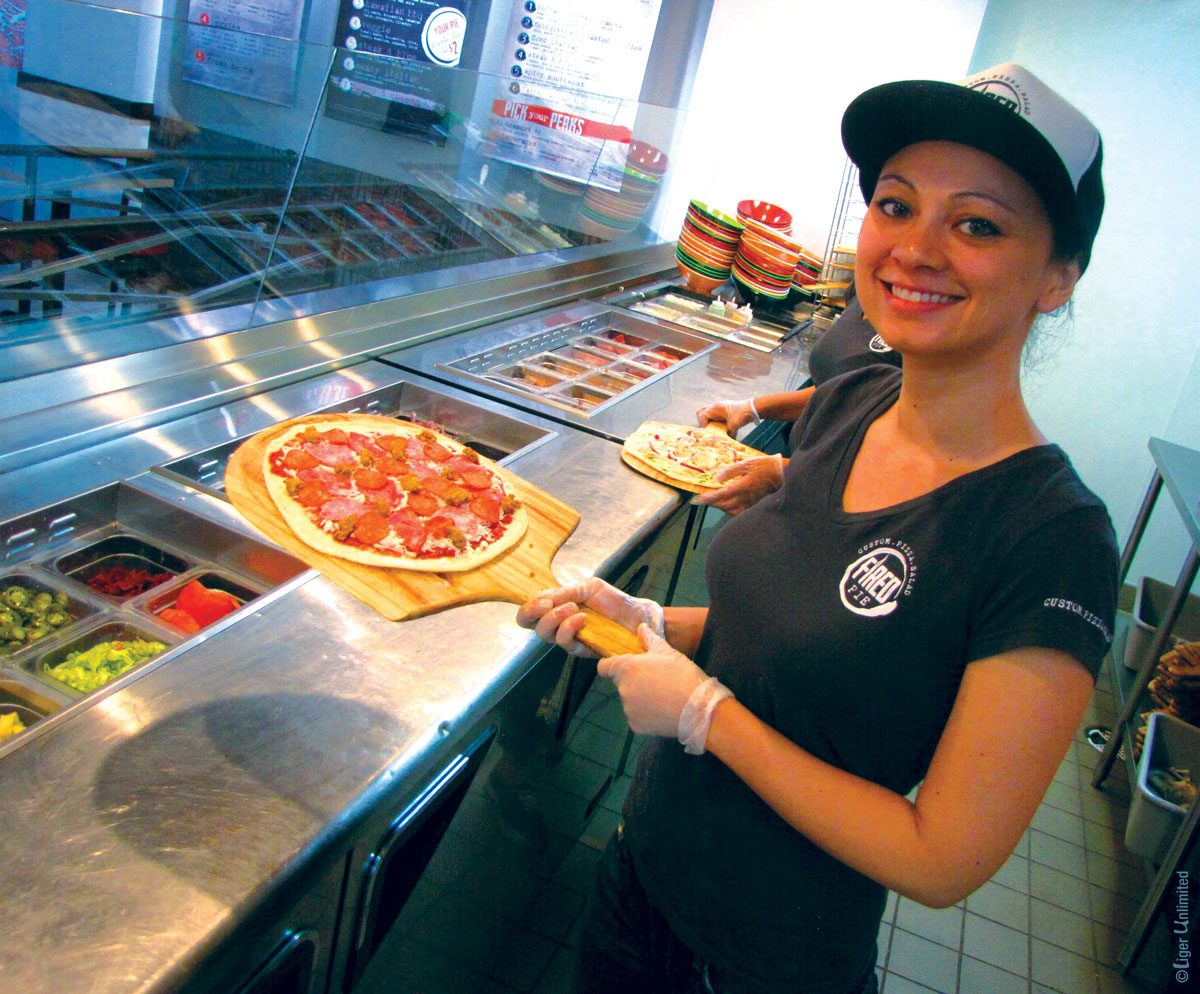 girl holding fired pie pizza