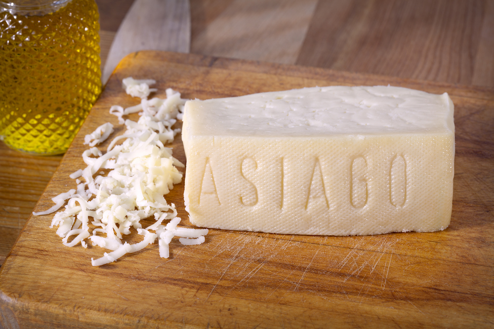 this photo depicts Asiago to illustrate the different types of hard cheeses that can be used for pizzas.