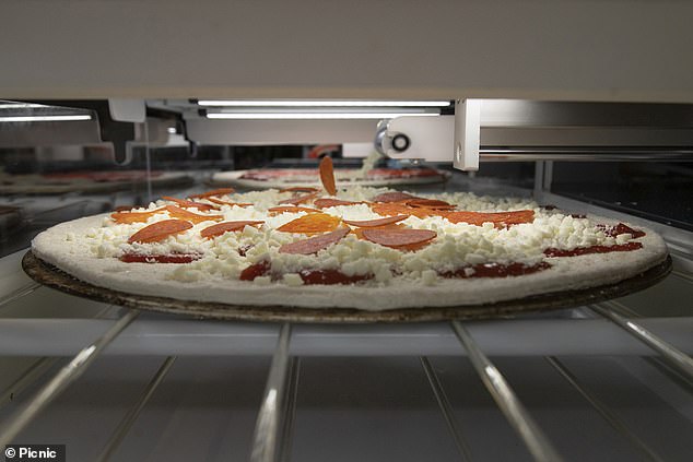 this picture shows the pizza-making robot in action in a kitchen