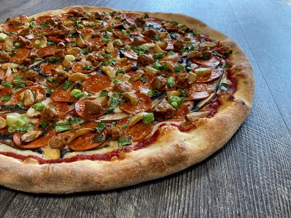 this photo shows a pizza topped with plant-based pepperoni from vegan meats company Field Roast
