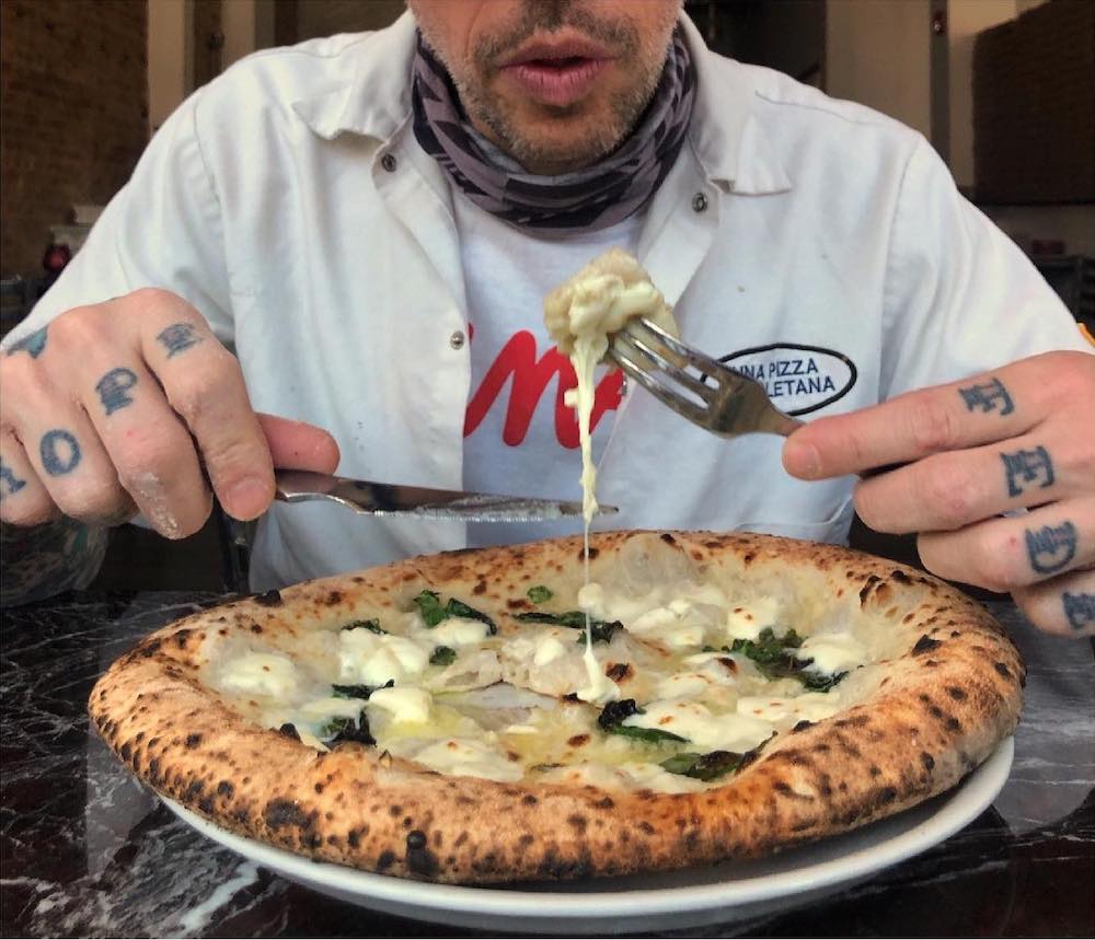 this photo shows Anthony Mangieri tasting a pizza at Una Pizza Napoletana, named one of the country's best pizzerias