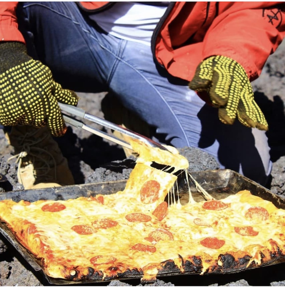 this photo shows a cheesy pizza made at the foot of Guatemala's Pacaya volcano