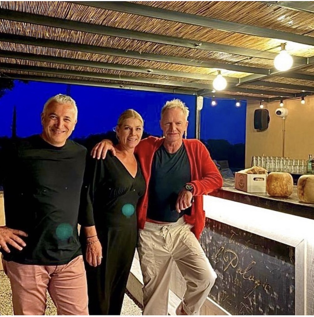 this photo shows rock star Sting with staff at his new pizzeria and wine bar in Tuscany, Italy