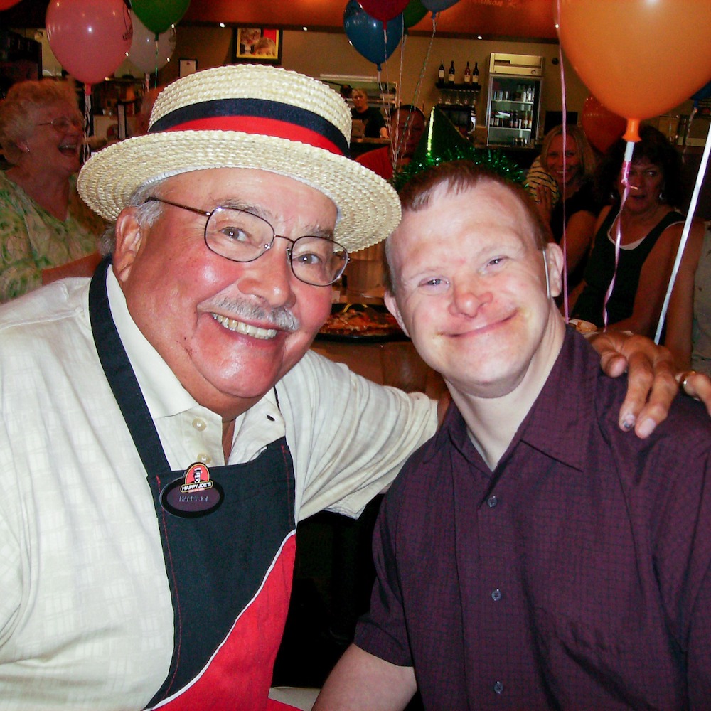 this is a photo of Joe Whitty, founder of Happy Joe's Pizza and Ice Cream Parlor, with a boy who has Down syndrome