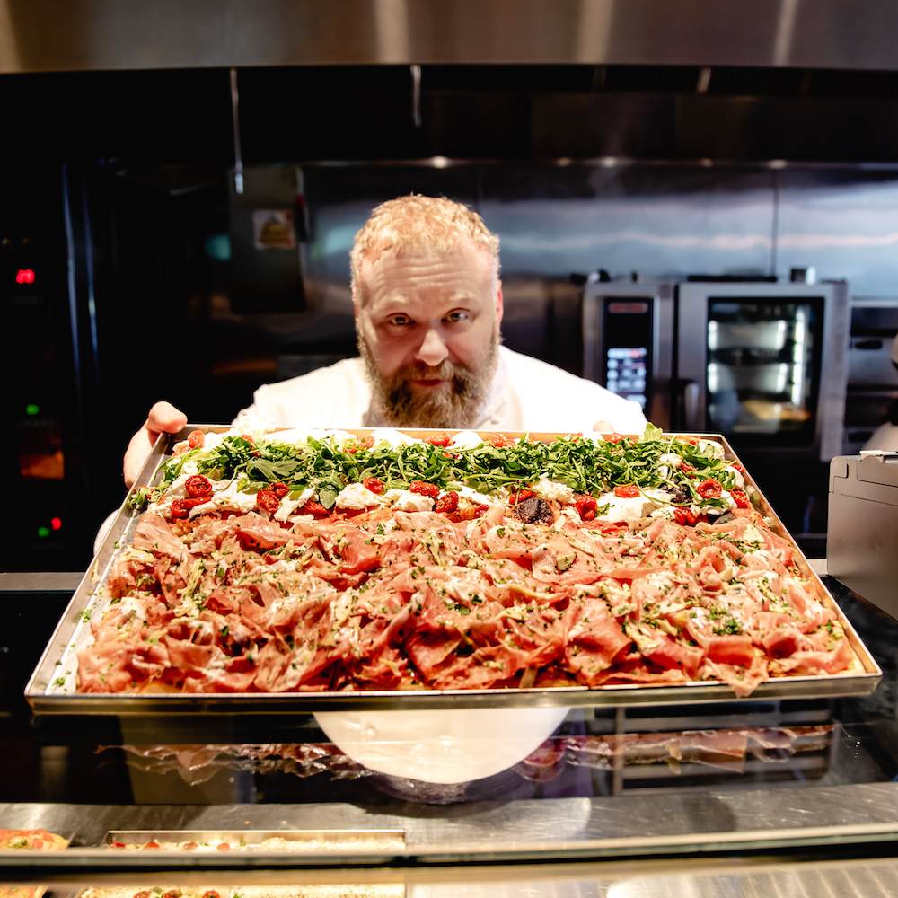 this photo shows renowned pizza chef Gabriele Bonci with a Roman-style pizza.