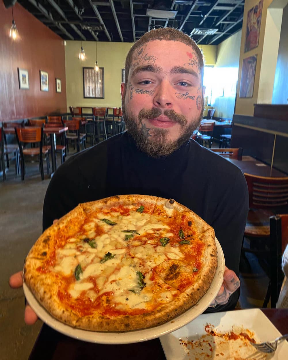 this photo shows rapper Post Malone with a pizza at Settebello Pizza Napoletana in Salt Lake City