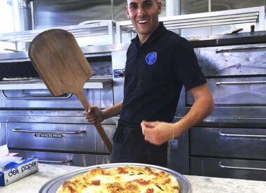 this photo shows Peter Izzo with a pizza he made at Peter's Pizzeria