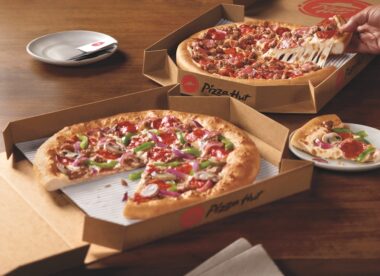 this photo shows two Pizza Hut pizzas with various toppings in branded delivery/carryout boxes