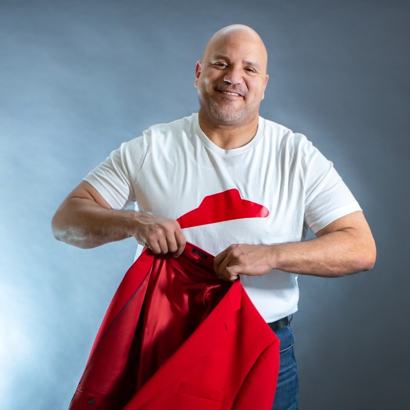 this photo shows Aaron Powell removing a red jacket to show a Pizza Hut T-shirt