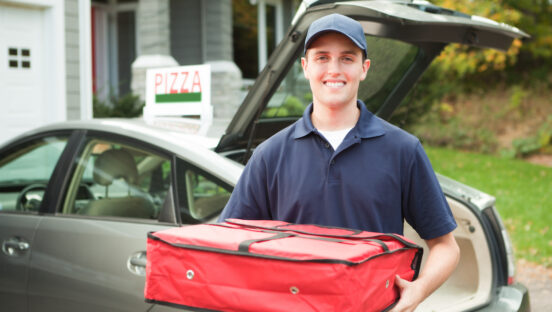 A take-out pizza delivery man delivering take-out food to customer's home.