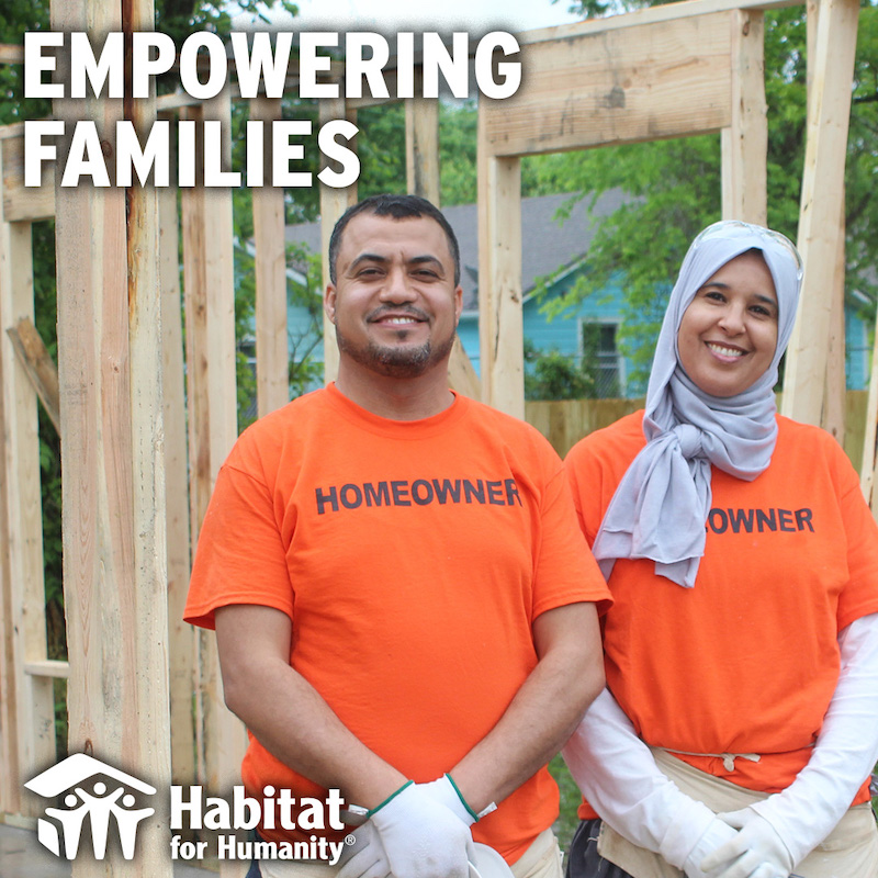 this photo shows a couple, with the woman in a burka, and both wearing orange t-shirts that say "Homeowner," standing in front of a house that's under construction