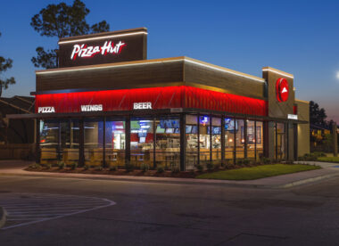 this is a nighttime scene showing the brightly lit exterior of a Pizza Hut restaurant