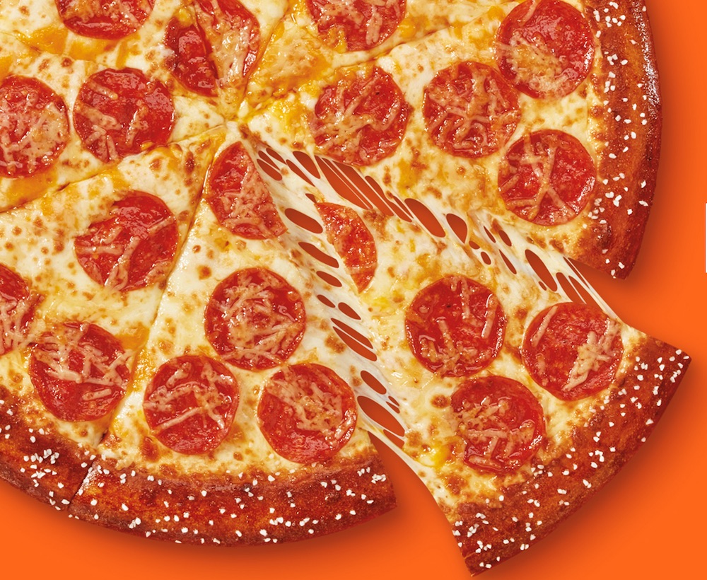 this shows a whole Little Caesars pizza with one detached slice and a crust that features a soft pretzel dough