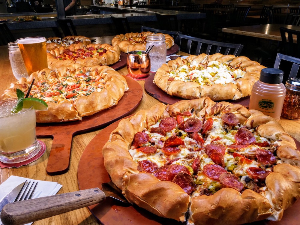 this photo shows several Colorado-style pies with braided crusts and various toppings