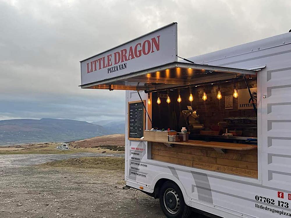 this shows the exterior of the Little Dragon Pizza Van set against the dramatic backdrop of the Welsh moors