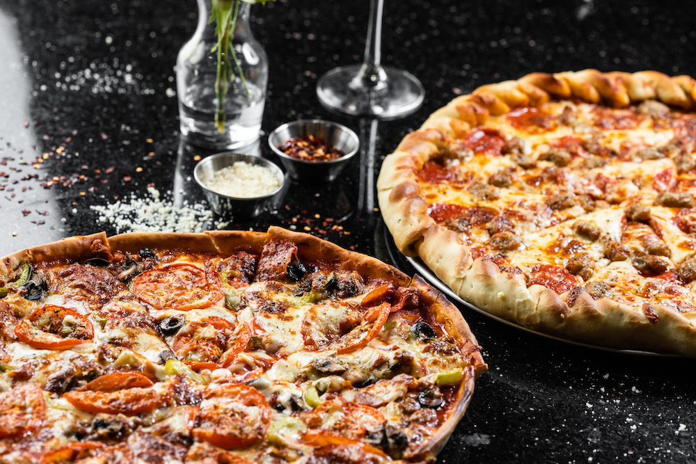 this photo shows both a tavern-style thin-crust pizza and a Dallas-style pizza