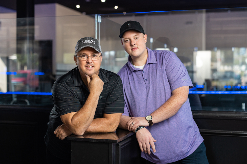 this photo shows Andrew Albert and Justin Albert, leaning against each other, in the dining room at Andrew's American Pizza Kitchen