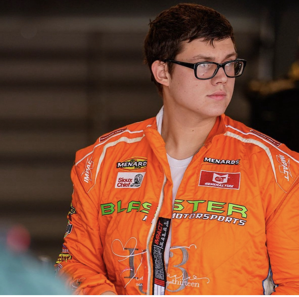 this photo shows Brayton Laster in his pizza-themed racing jacket, wearing glasses and looking slightly away from the camera