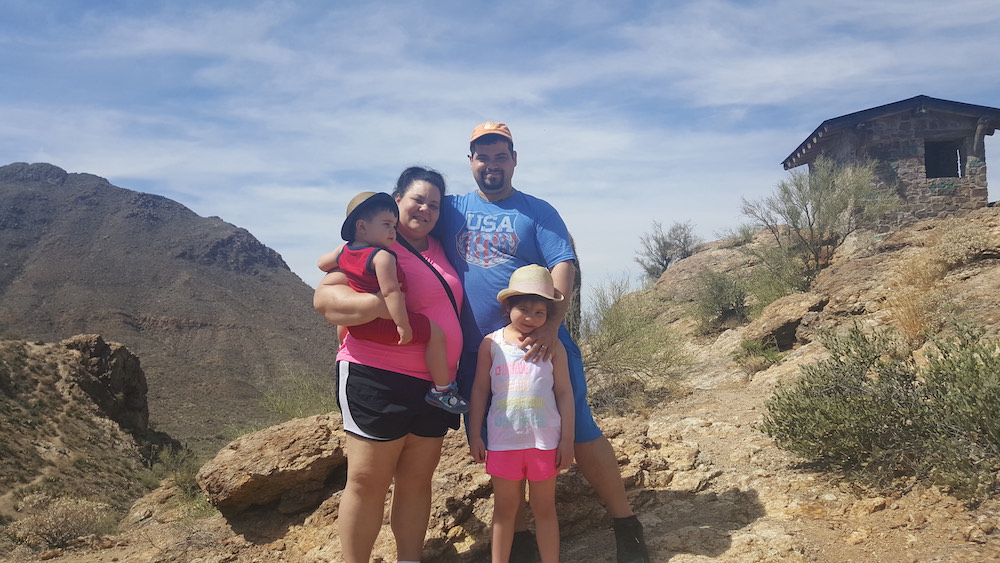 this photo shows the entire Cinelli family, including their two young children, in an outdoor setting that looks like it's in the American west