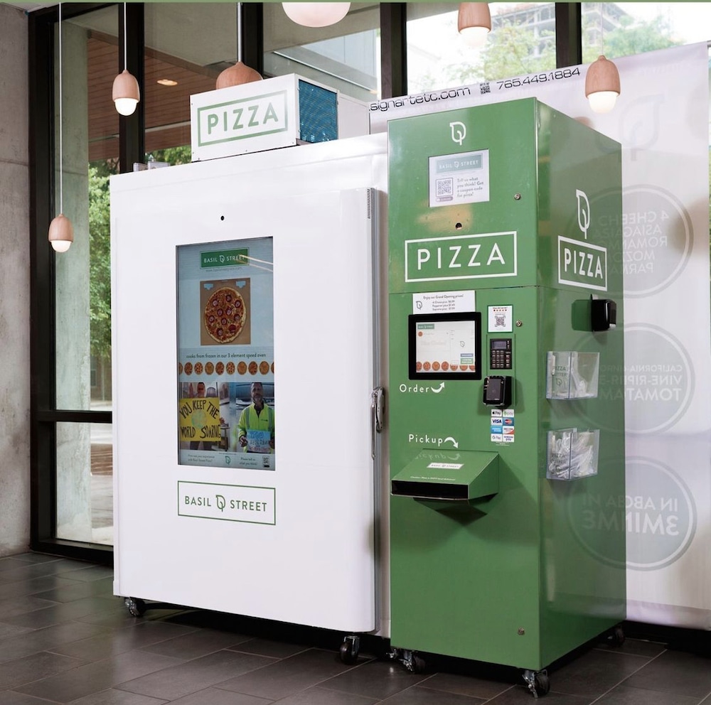 this photo shows a Basil Street pizza vending machine. The pizza-storage and baking section is white, while the ordering section is green.