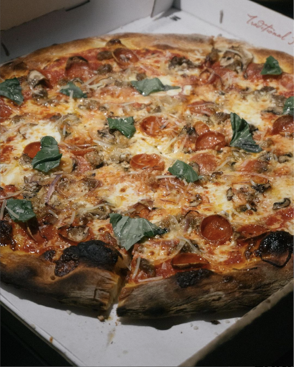 Photo shows a Bird Pizzeria pie with pepperoni and herbs. 