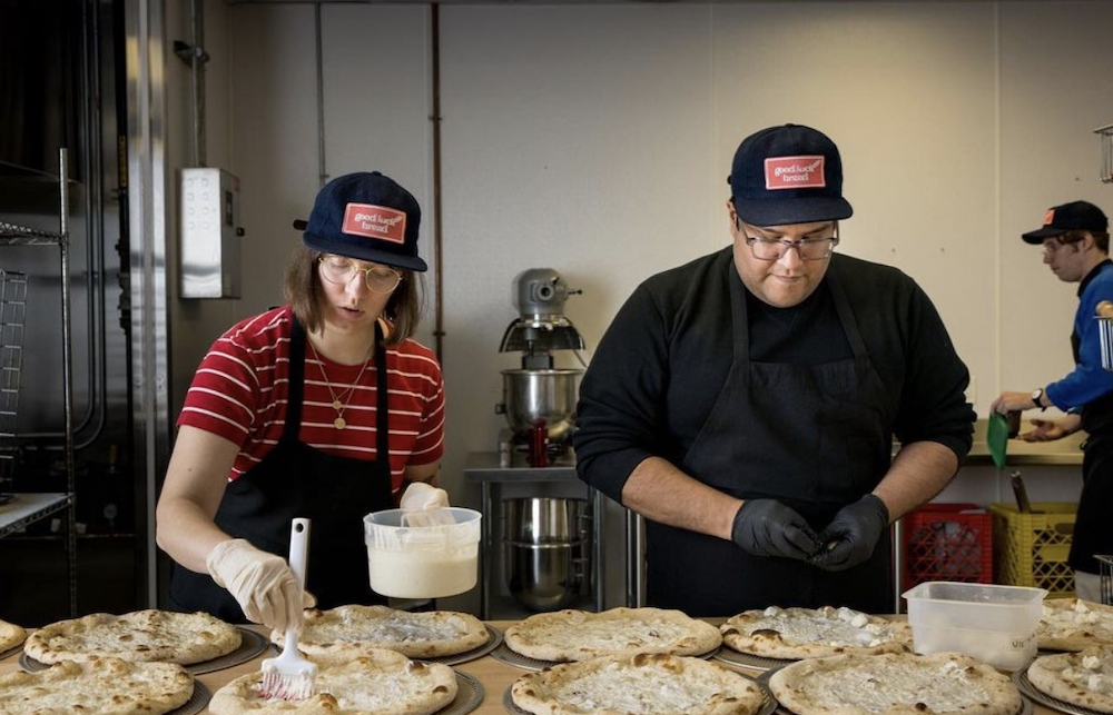 A pair of pizza makers prep frozen pies for Good Luck Bread out of Seattle.