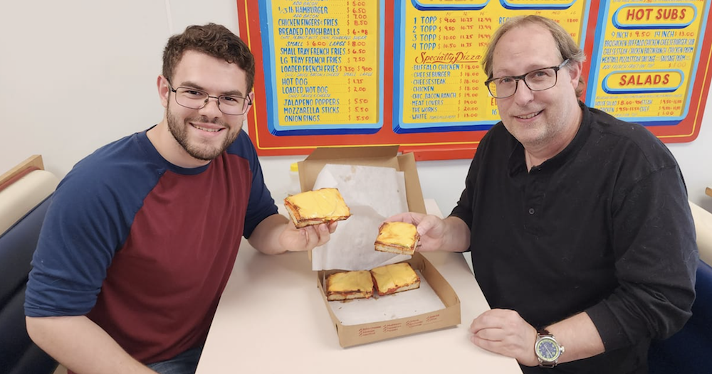 Two men sit ready to eat their Altoona-Style pizza.