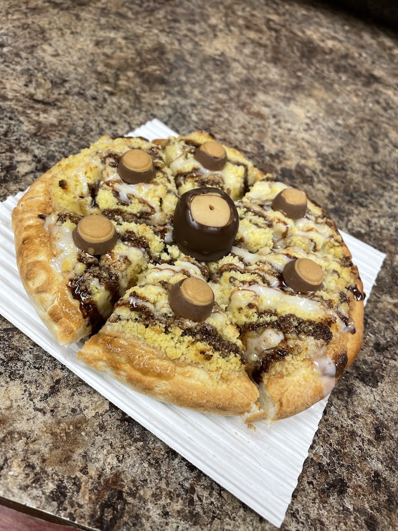 This photo shows the Buckeye Eye Dessert pizza with peanut butter sauce, streusel, icing, chocolate syrup and buckeye candies.