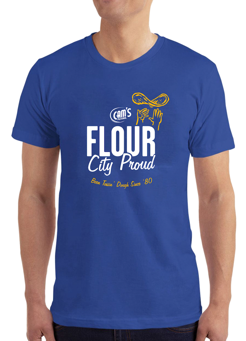 This photo shows a young man from the neck down, wearing a blue t-shirt that reads Cam's: Flour City Proud