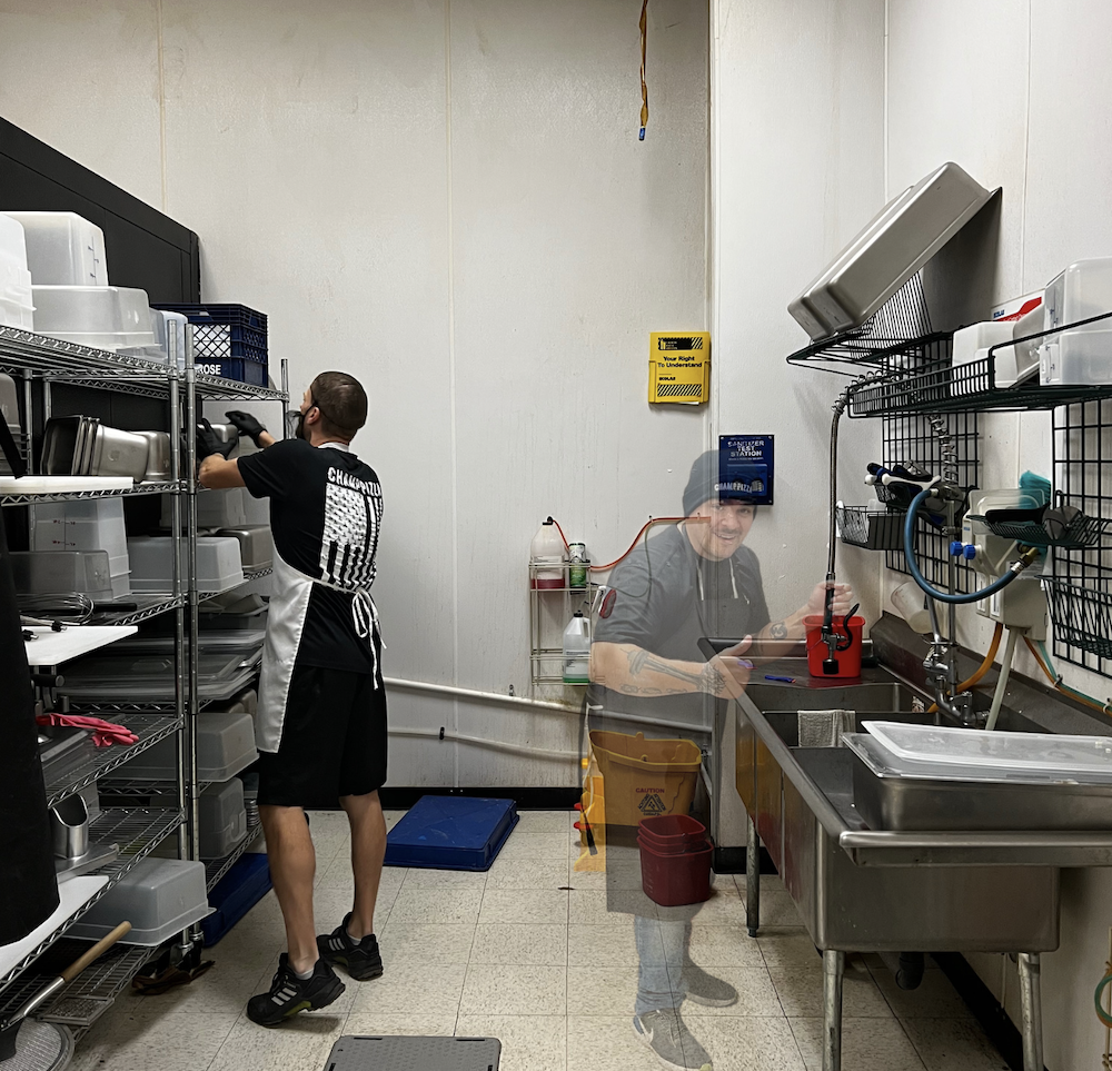 What appears to be ghost washes dishes in a restaurant, although the picture is obviously deliberately Photoshopped for fun.