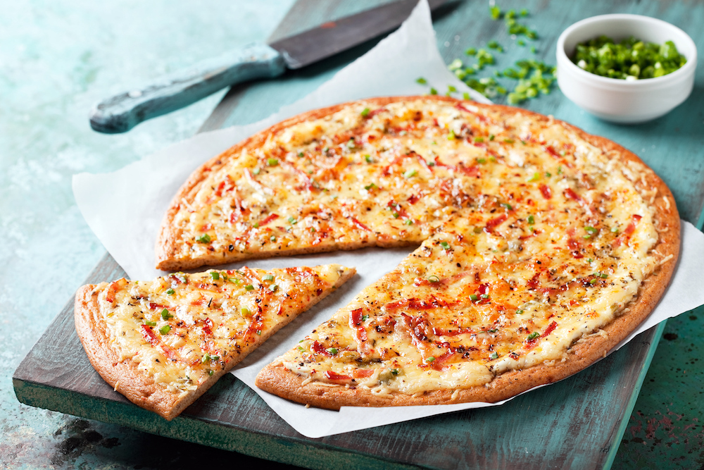 White pizza with bacon and green onions, gluten free, selective focus