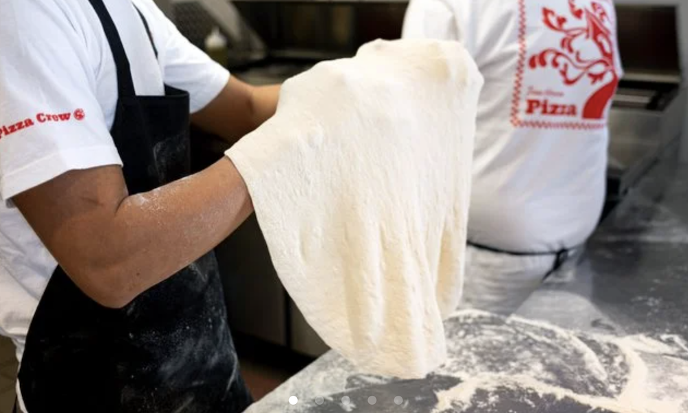 Treehouse Pizza kitchen employees toss dough.