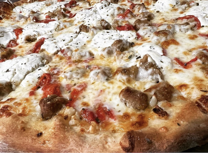 This photo shows a delicious-looking pizza topped with sausage and roasted red peppers.