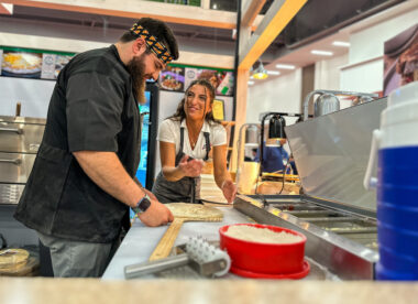 This photo shows Giuliana Calascibetta teaching a new employee how to make pizza.