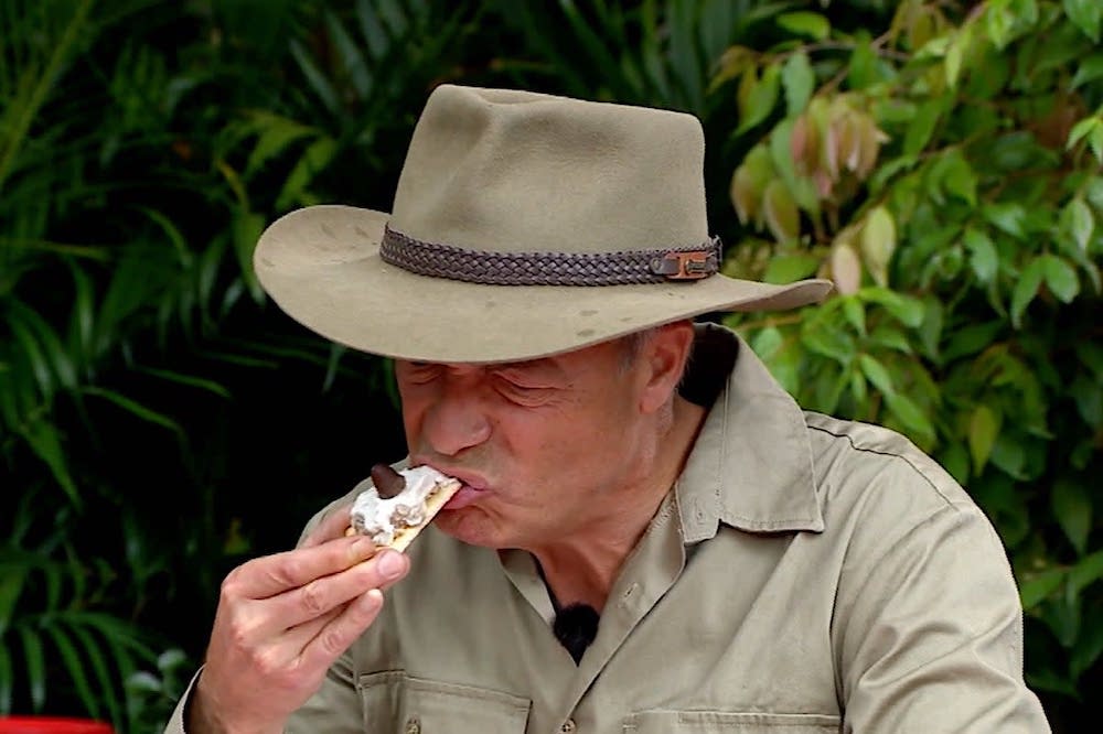 This photo shows Nigel Farage, wearing a sporty Aussie-style hat, taking a bite of a pizza topped with camel's udder, cow's udder and a cow's teat.