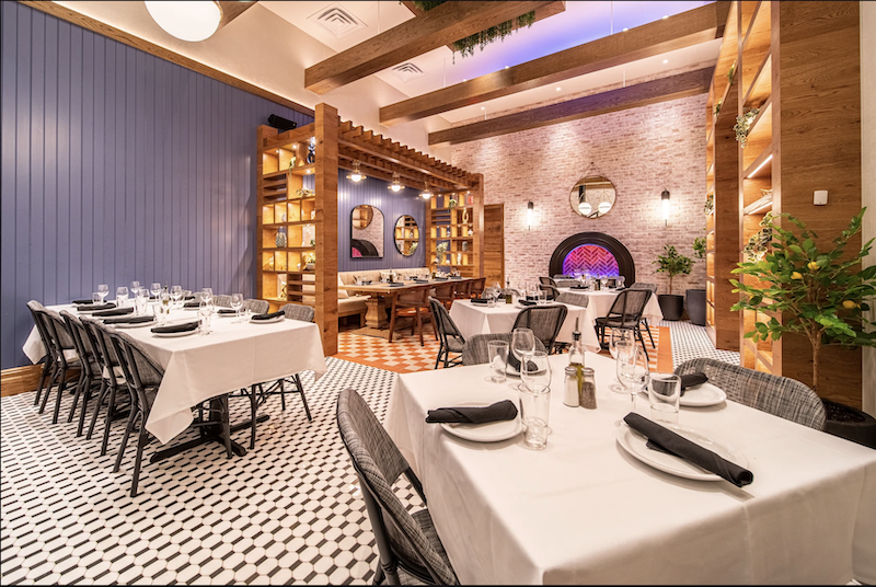 This photo shows the interior of Patricia's, with beautiful chandeliers, light fixtures and white tablecloths.