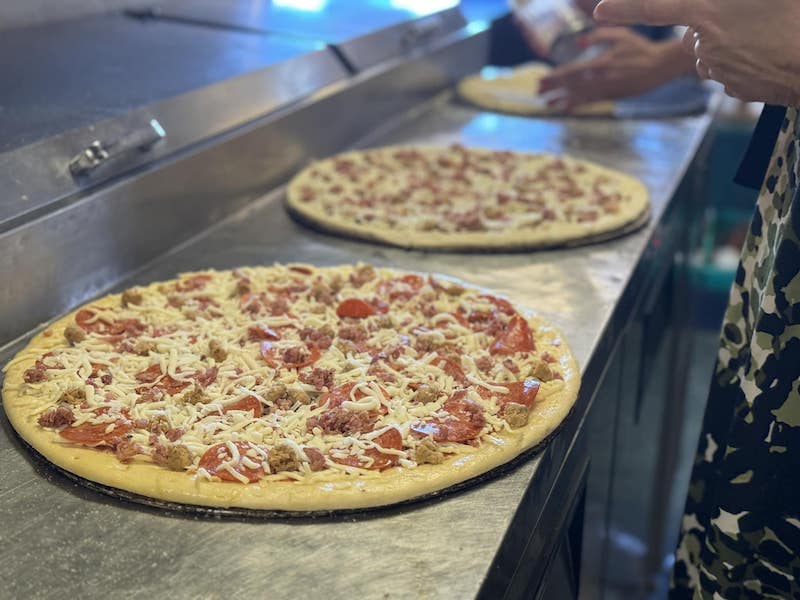 This photo shows a pizza topped with pepperoni, sausage and cheese