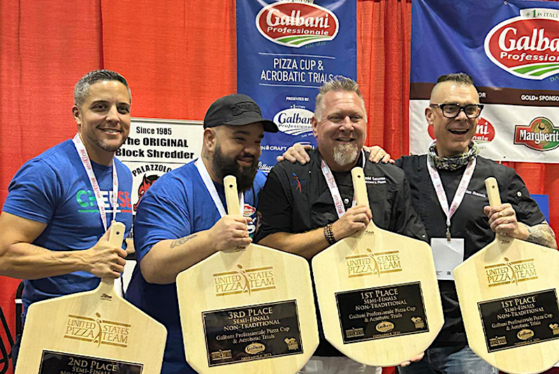 This photo shows top performers in the Galbani Professionale Pizza Cup all lined up together and showing their trophy pizza peels.