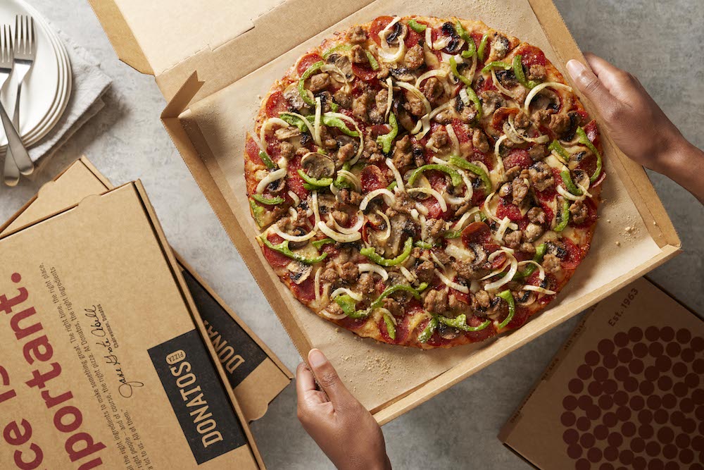 This photo shows a thin-crust Donatos Pizza topped with sauce, smoked, Provolone and, Romano cheese, pepperoni, sausage, mushrooms, green, peppers and onions.