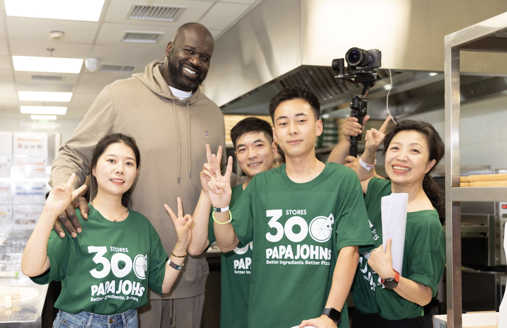 basketball star Shaquille O'Neal poses with Papa Johns employees in honor of Papa Johns opening its 300th store in China.