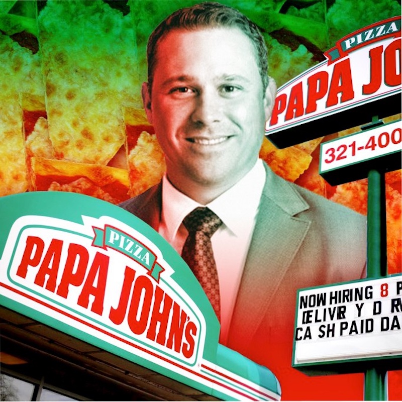 This photo shows Rob Lynch with a Papa Johns sign in front of him and another one behind him.