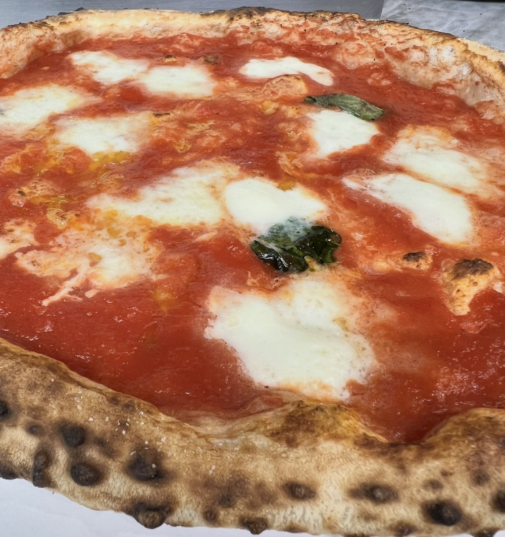 A beautiful Margherita pie by Pizza Luca with brown leoparding on the crust.