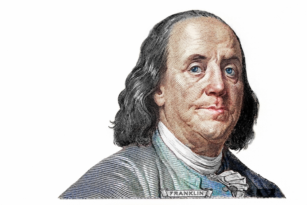 This photo shows a Benjamin Franklin cut on new 100 dollars banknote isolated on white background