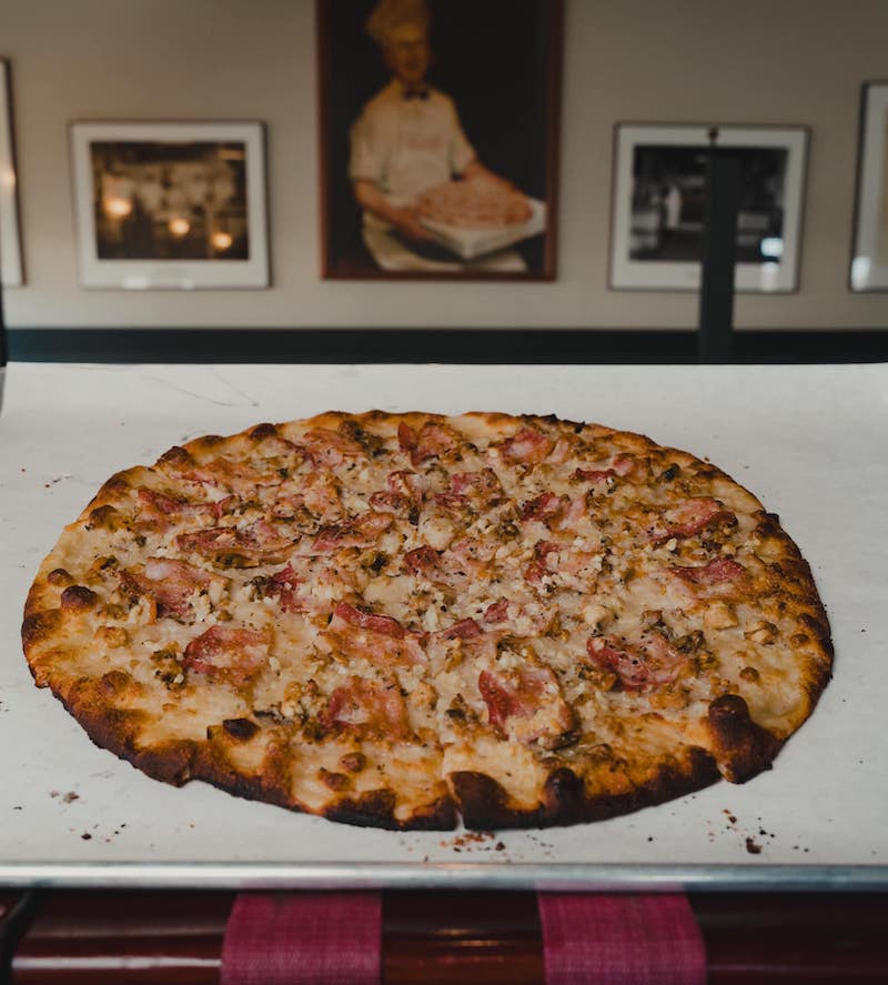 This photo shows a pizza topped with clams and bacon.