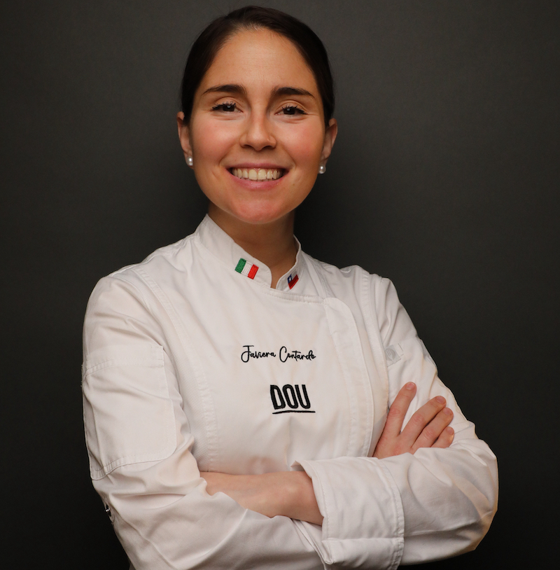 This photo shows Javiera Contardo, arms crossed, in a white chef's coat.