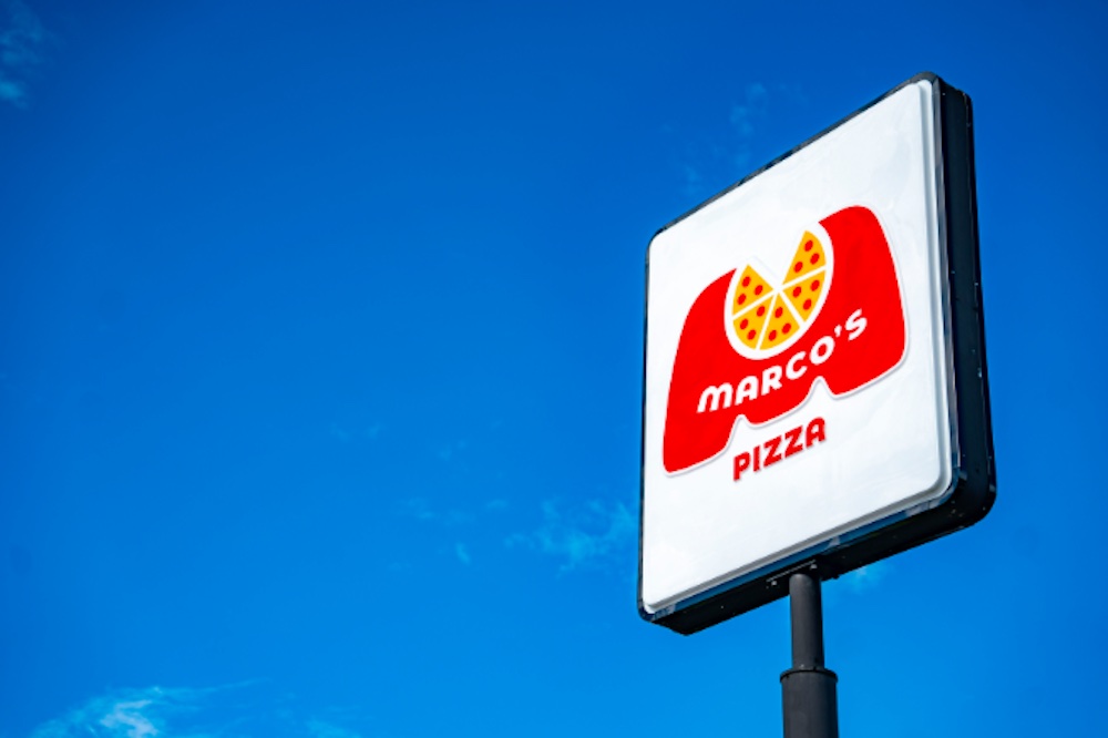 This photo shows the Marco's Pizza exterior sign set against a dark blue sky.
